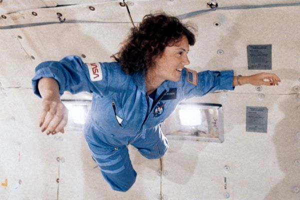 Astronautin schwebt in Schwerelosigkeit durch das Innere einer Raumfähre.