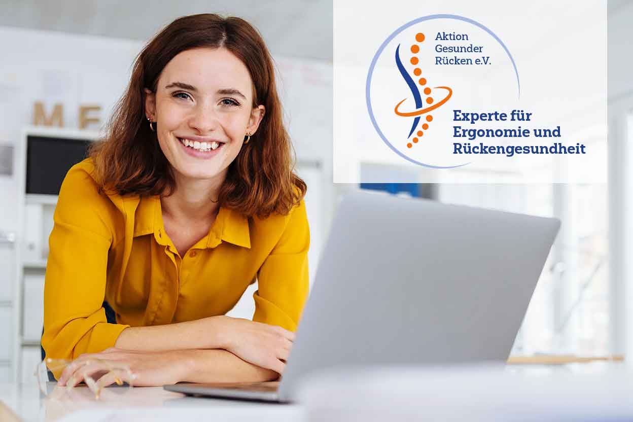 Junge Frau lehnt an einer Wand und hält eine AGR-Broschüre in den Armen.