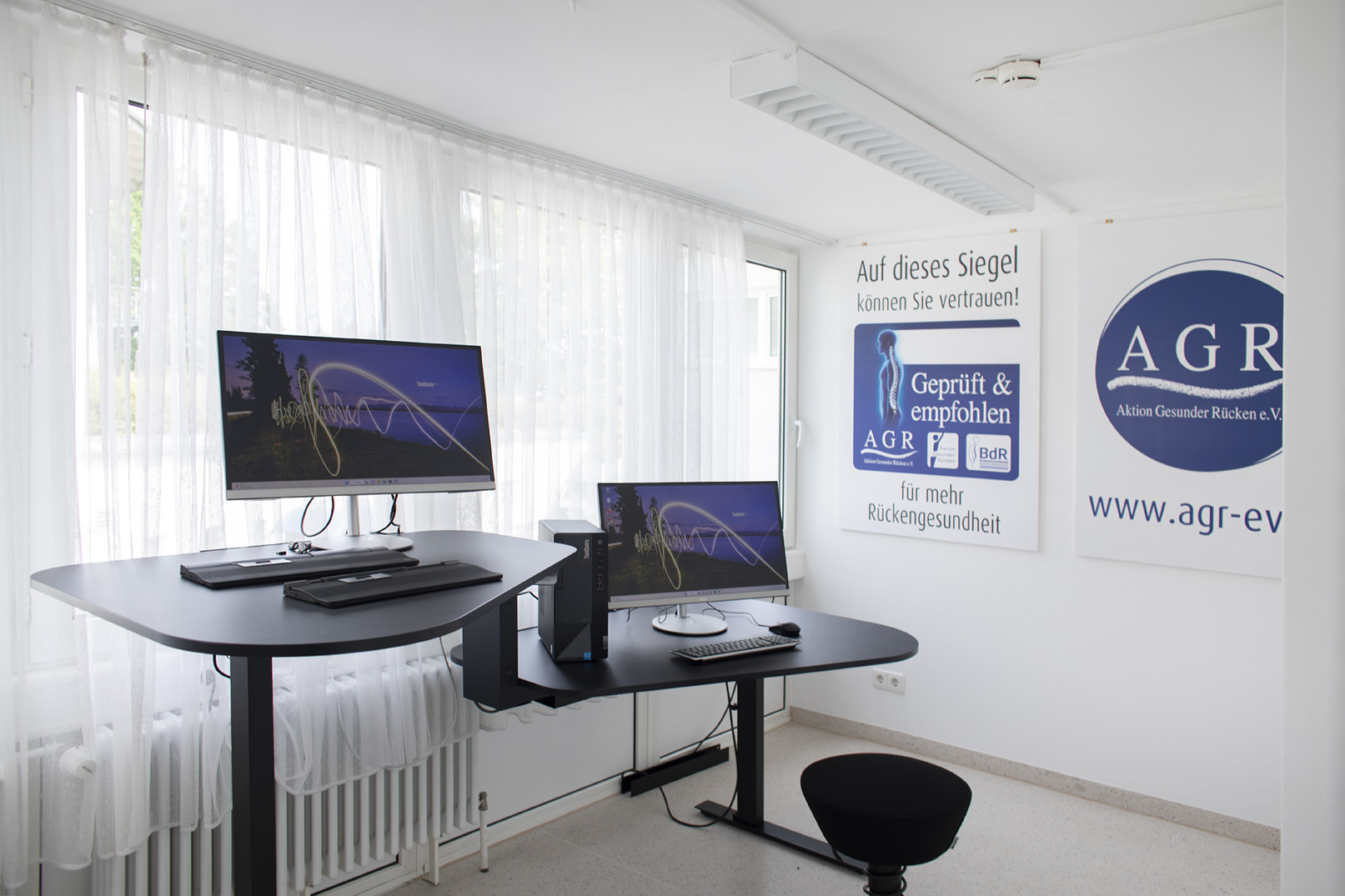 Ergonomisch eingerichtetes Büro mit höhenverstellbarem Schreibtisch und Monitor