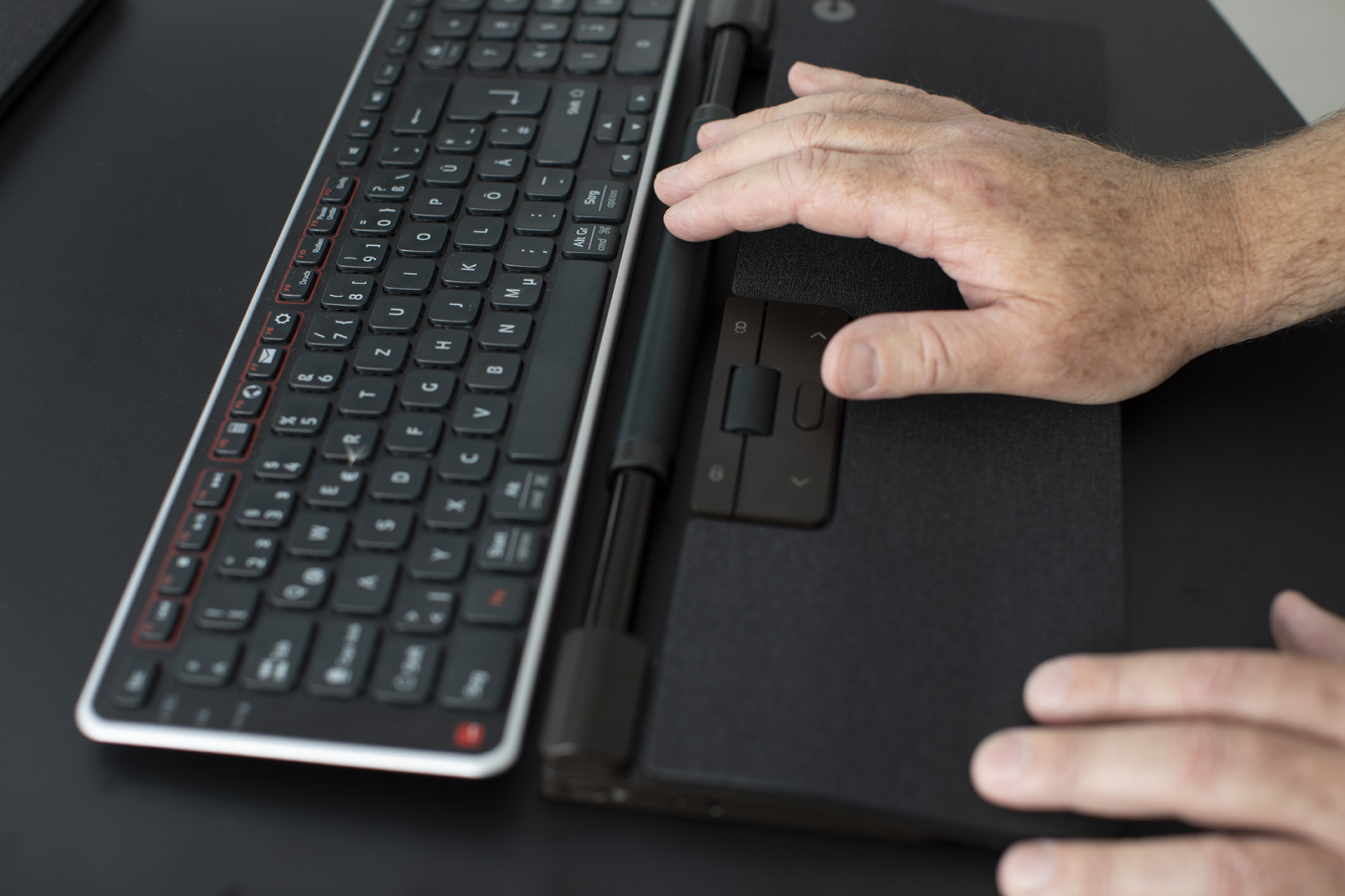 Hände tippen ergonomisch auf einer Tastatur mit Handballenauflage