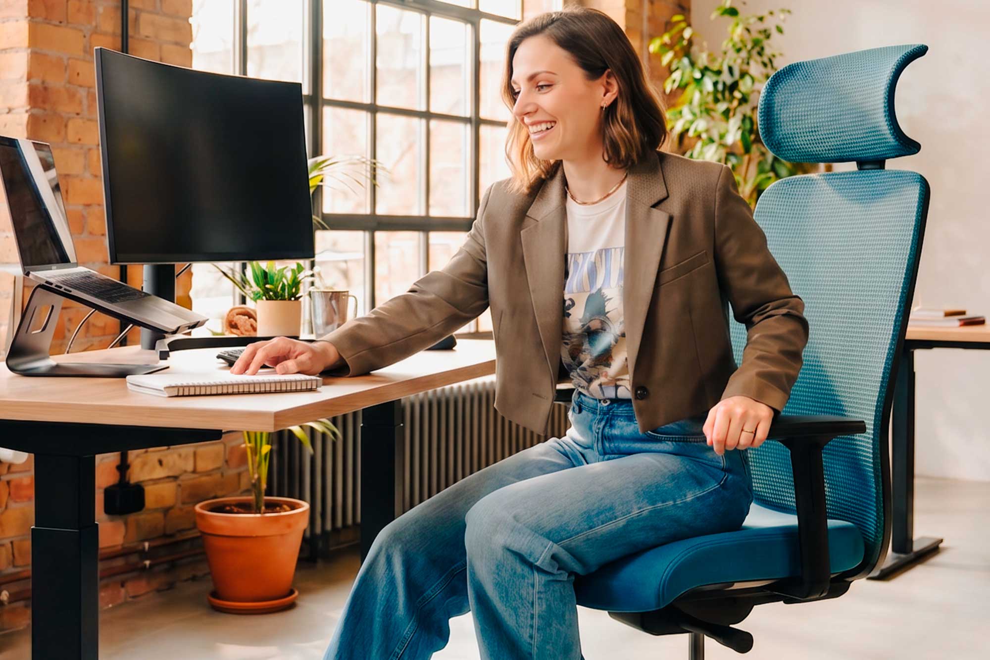 Frau sitzt auf dem ergonomischen Bürostuhl Sitness AirWay von Topstar an einem Schreibtisch