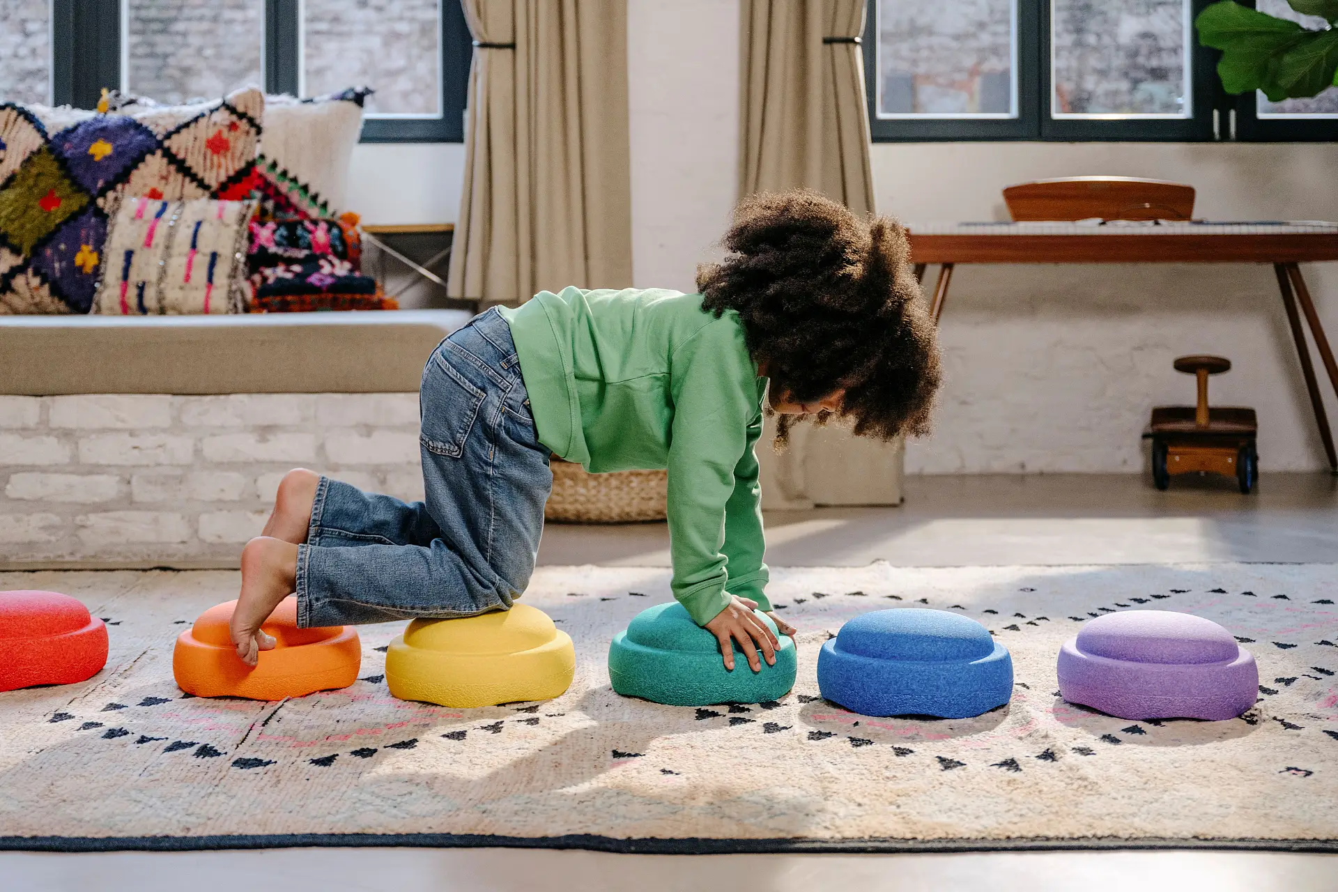 Ein Kind klettert über bunte Stapelsteine